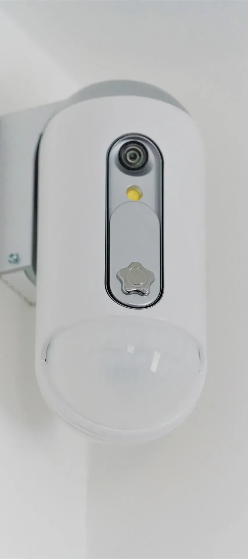 Wall-mounted indoor security camera in a white housing