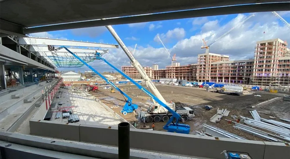 The main stand under construction, with a crane and two access platforms on the pitch