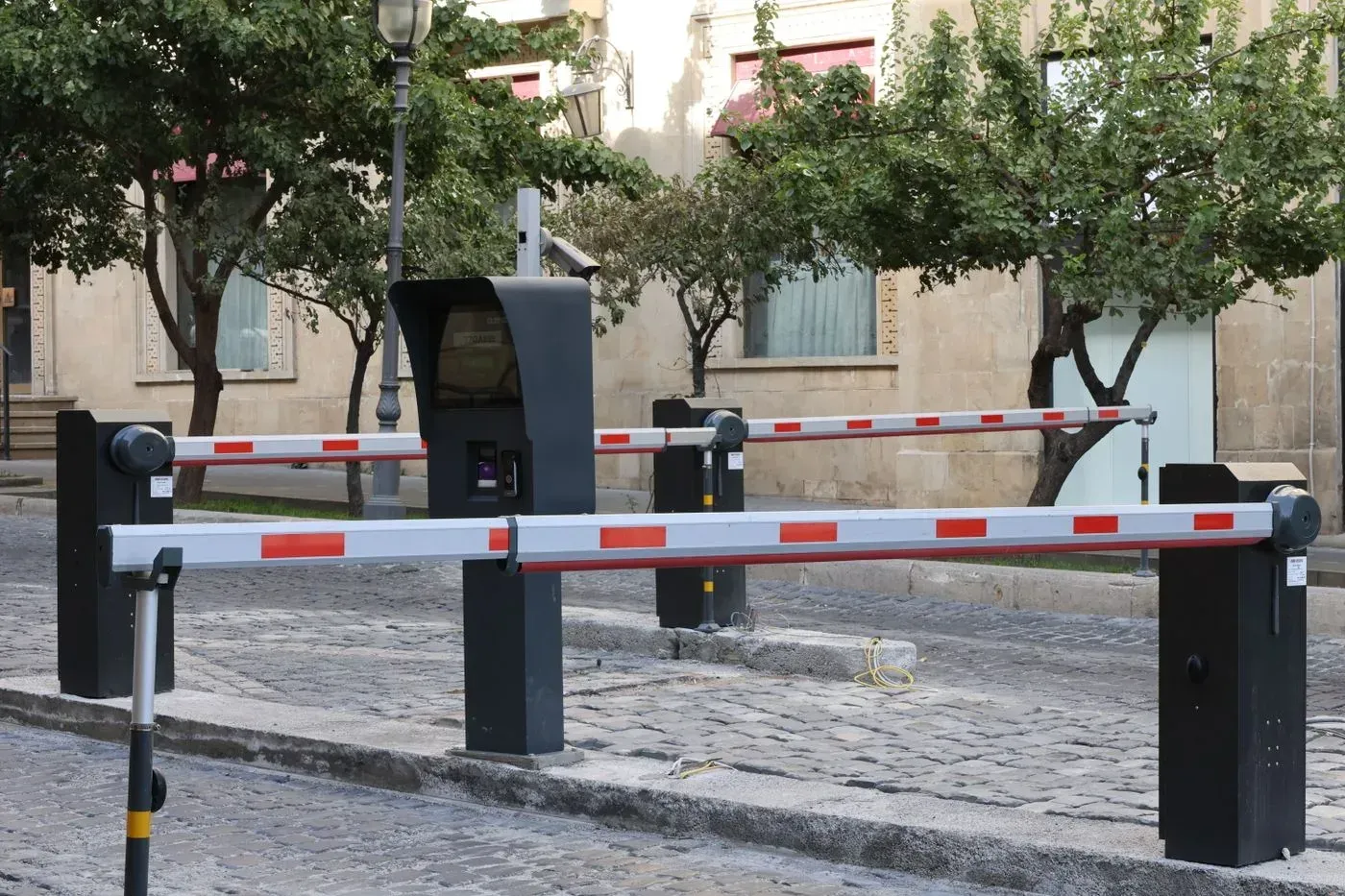 Vehicle entrance with rising-arm barriers and a central control pedestal