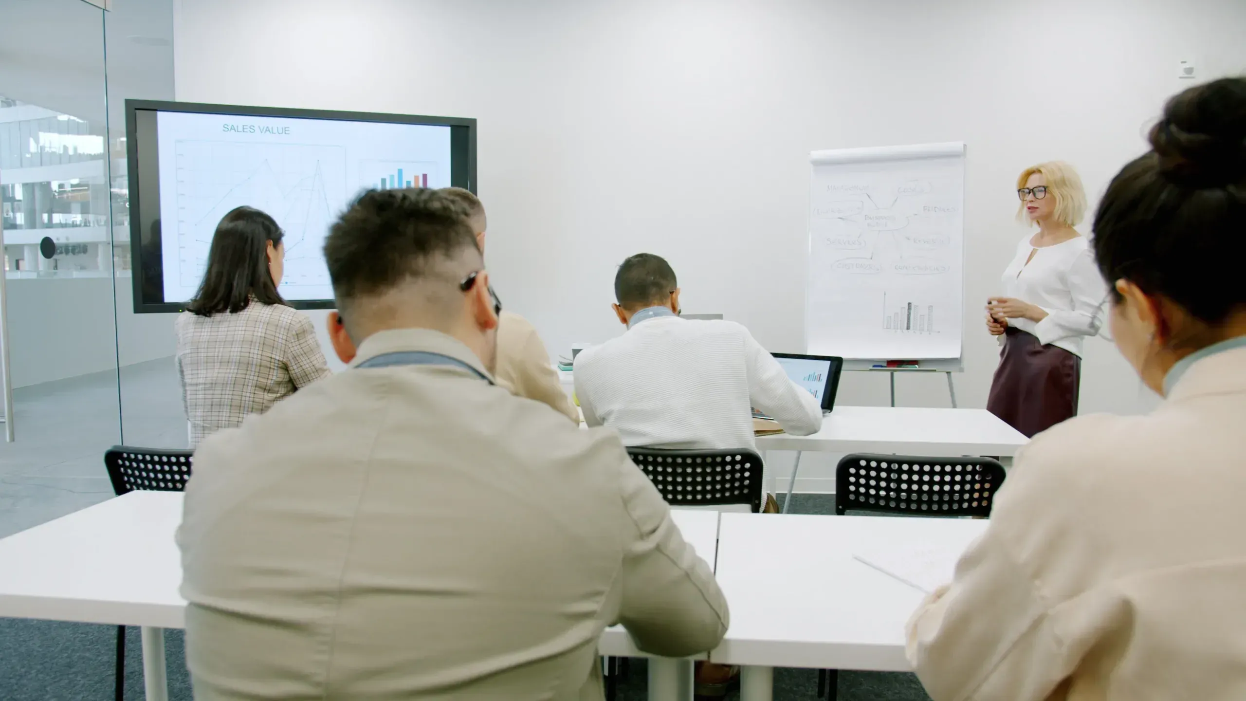Trainer at a flipchart leading a session in a bright modern office