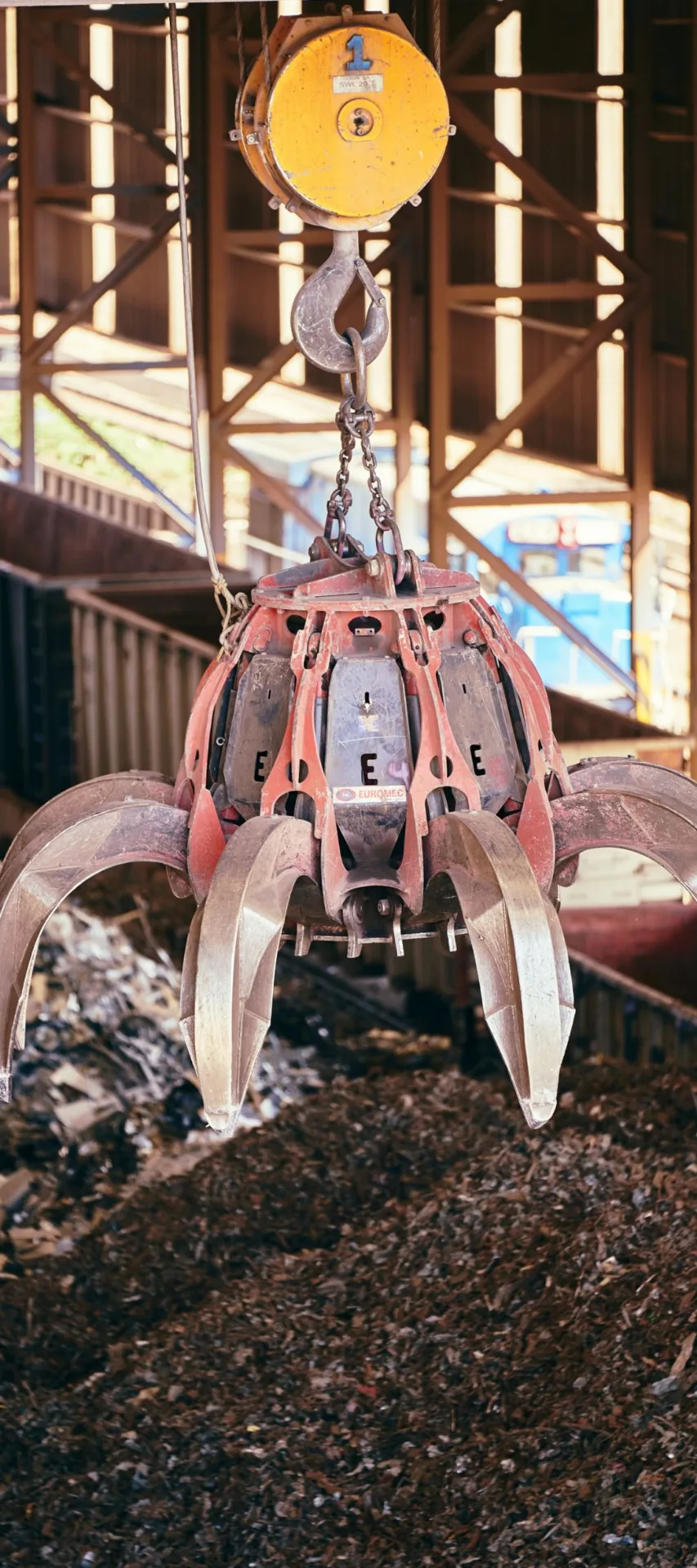 Grab crane lifting scrap metal at a waste processing site
