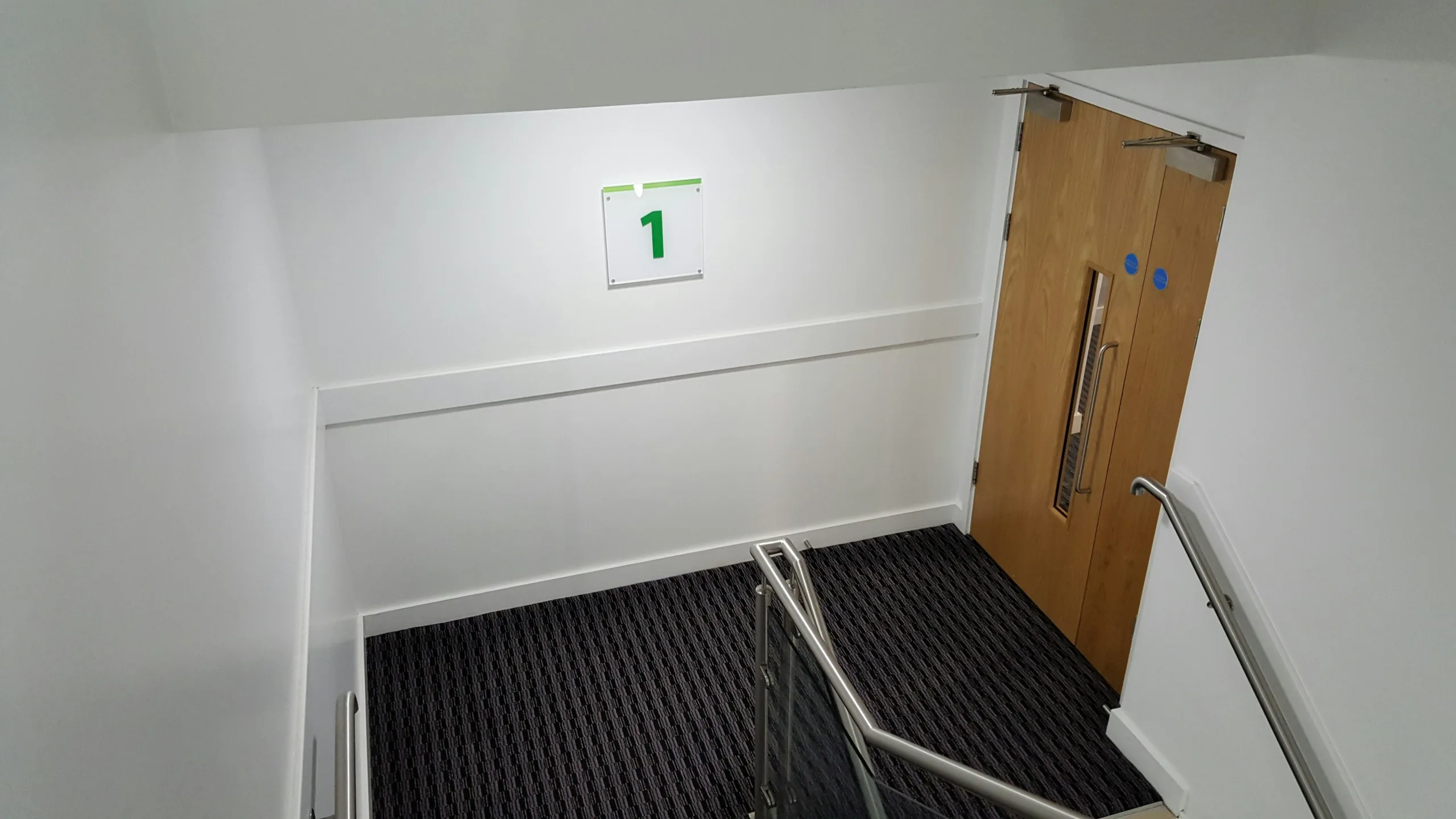 Stair landing with a fire door and a floor number sign