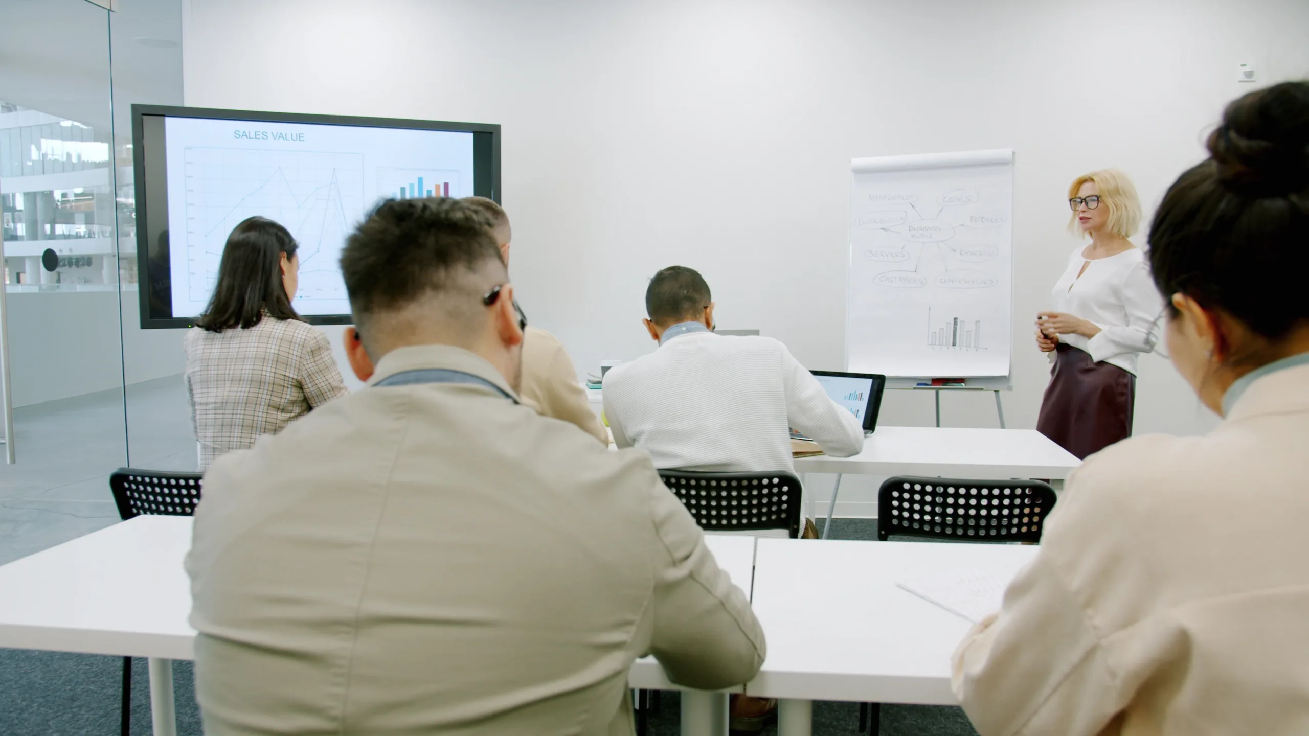 Trainer at a flipchart leading a session in a bright modern office