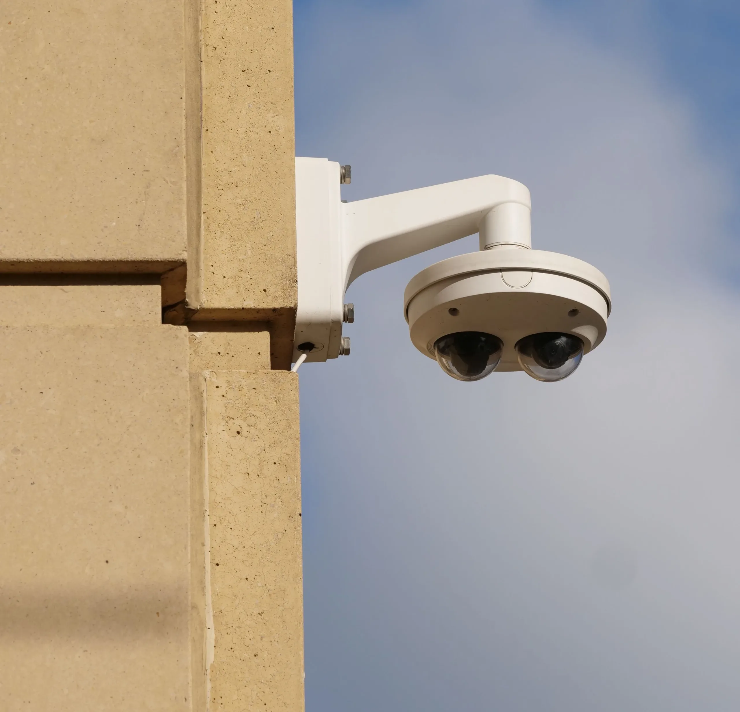 Same multi-sensor camera, mirrored and trimmed so it hangs in the clear half against the sky