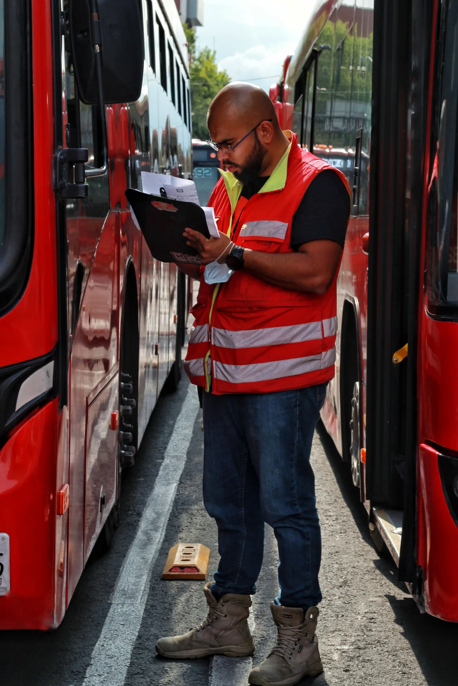 Worker with a clipboard beside a bus
