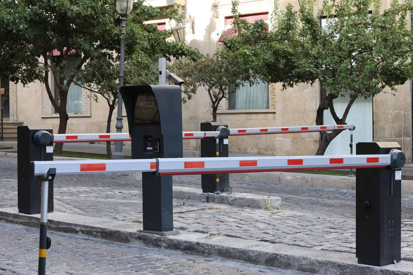 Vehicle entrance with rising-arm barriers and a central control pedestal